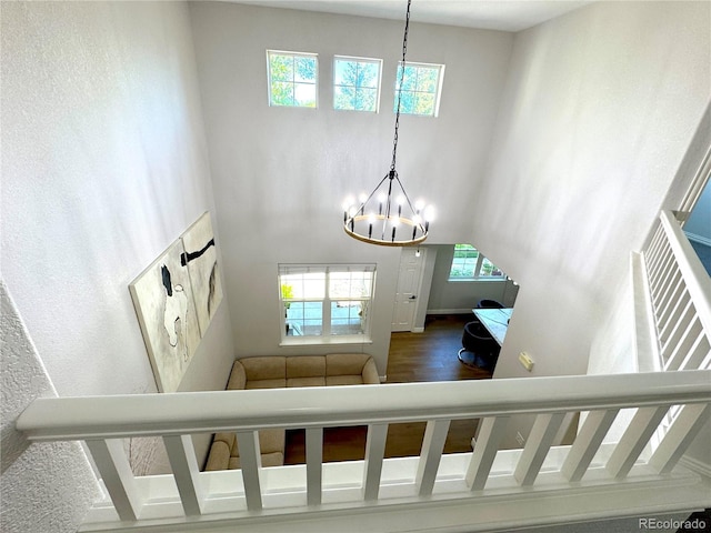 12743 W Bowles Pl, Littleton, CO 80127 - stairway with a chandelier, a high ceiling, and wood finished floors