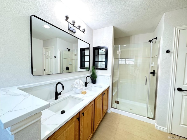 12743 W Bowles Pl, Littleton, CO 80127 - full bath with a shower stall, a textured ceiling, double vanity, and a textured wall