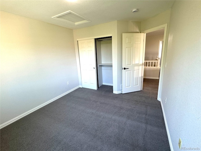 12743 W Bowles Pl, Littleton, CO 80127 - unfurnished bedroom featuring attic access, baseboards, dark colored carpet, a closet, and a textured ceiling