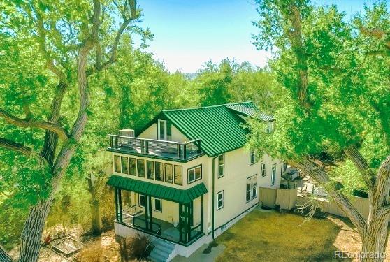 3 S Newton St, Denver, CO 80219 - back of house featuring a balcony, a standing seam roof, a metal roof, and stucco siding