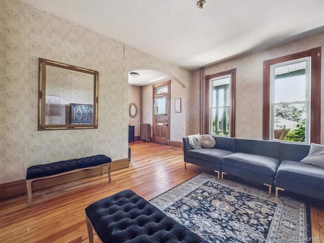3 S Newton St, Denver, CO 80219 - living area featuring arched walkways, wallpapered walls, hardwood / wood-style floors, and radiator