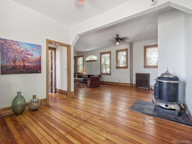 3 S Newton St, Denver, CO 80219 - unfurnished living room with radiator, a wood stove, a ceiling fan, and hardwood / wood-style flooring