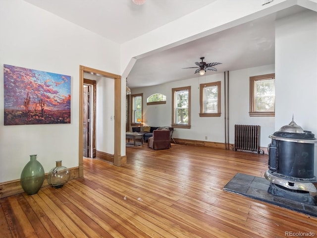 3 S Newton St, Denver, CO 80219 - living area with radiator, a wood stove, light wood-style flooring, and ceiling fan
