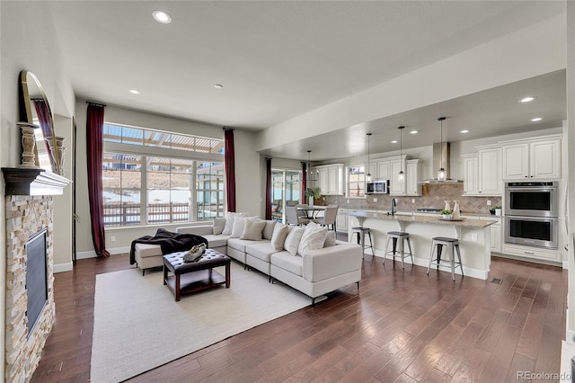 living room with sink, a fireplace, and dark hardwood / wood-style floors