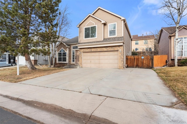 traditional home with brick siding, concrete driveway, a garage, and fence