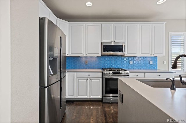 10388 Rutledge St, Parker, CO 80134 - kitchen featuring appliances with stainless steel finishes, white cabinets, dark wood-type flooring, light countertops, and recessed lighting