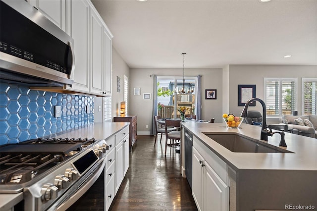 10388 Rutledge St, Parker, CO 80134 - kitchen with stainless steel appliances, tasteful backsplash, recessed lighting, a chandelier, and white cabinets