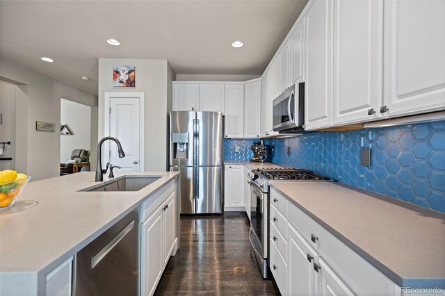 10388 Rutledge St, Parker, CO 80134 - kitchen featuring appliances with stainless steel finishes, white cabinets, backsplash, recessed lighting, and dark wood-type flooring