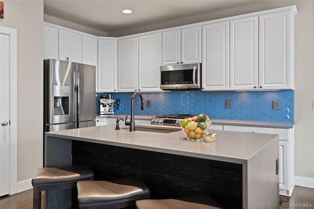 10388 Rutledge St, Parker, CO 80134 - kitchen featuring appliances with stainless steel finishes, white cabinetry, tasteful backsplash, and recessed lighting