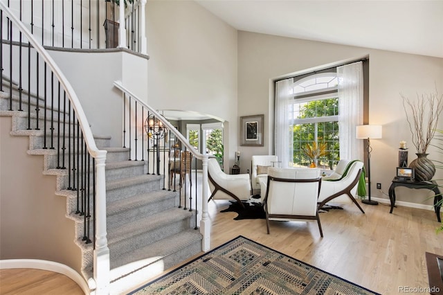 staircase featuring hardwood / wood-style floors and high vaulted ceiling