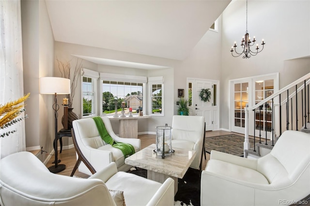 sitting room featuring a high ceiling, hardwood / wood-style floors, and an inviting chandelier