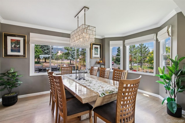 dining area featuring crown molding, a chandelier, and light hardwood / wood-style floors