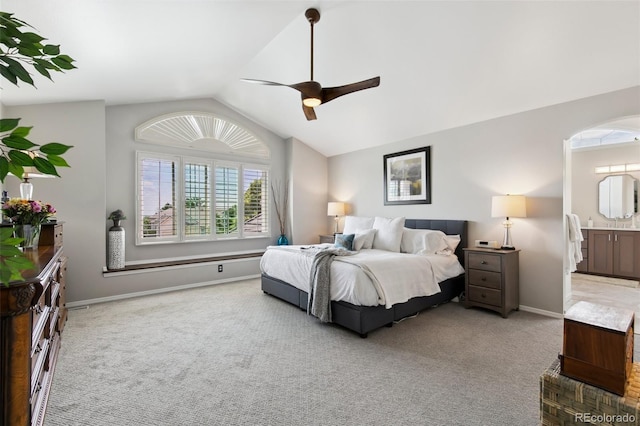 bedroom with lofted ceiling, light colored carpet, ceiling fan, and ensuite bath