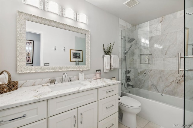 full bathroom featuring vanity, tile patterned floors, shower / bath combination with glass door, and toilet