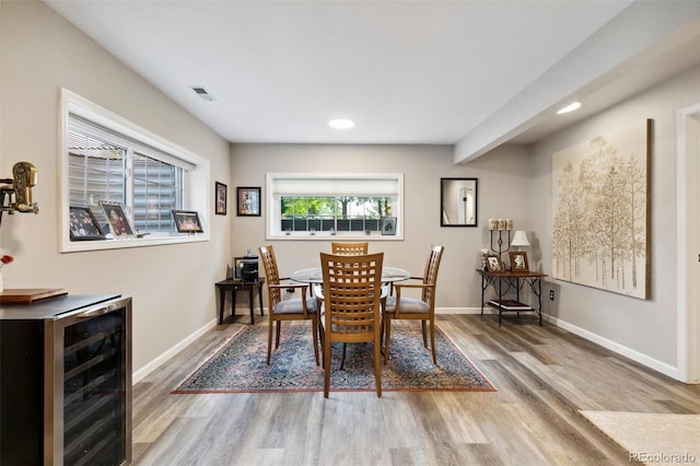 dining area with hardwood / wood-style flooring and beverage cooler