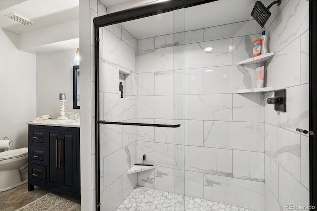 bathroom with vanity, a shower with shower door, and toilet