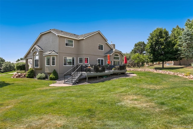 back of house featuring a wooden deck and a lawn