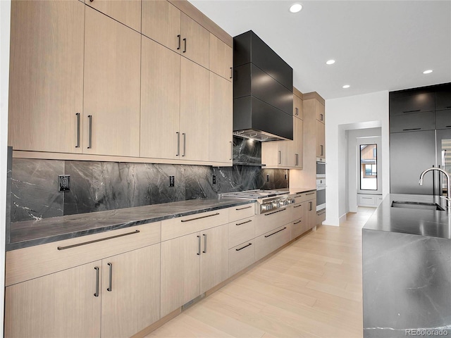 8132 Galileo Way, Littleton, CO 80125 - kitchen with a sink, wall chimney exhaust hood, modern cabinets, stainless steel gas stovetop, and light wood-type flooring
