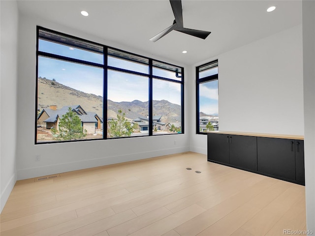 8132 Galileo Way, Littleton, CO 80125 - empty room featuring a ceiling fan, a mountain view, light wood-style flooring, and visible vents