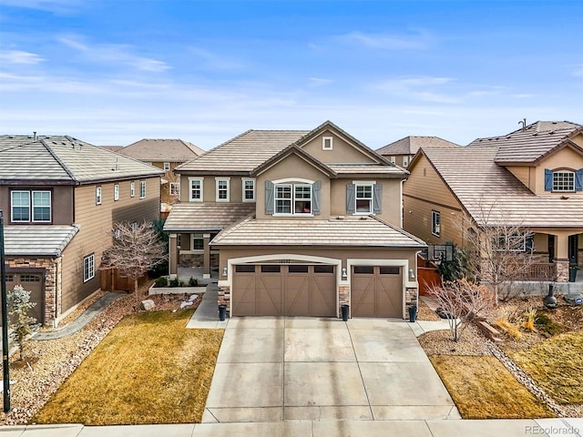 view of front facade featuring stone siding, a tile roof, concrete driveway, and stucco siding