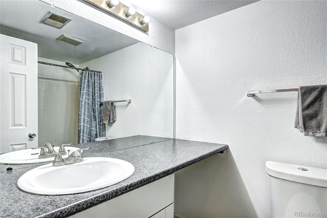 420 Wright St Unit 101, Lakewood, CO 80228 - full bathroom with a textured wall, toilet, a textured ceiling, vanity, and a shower with curtain