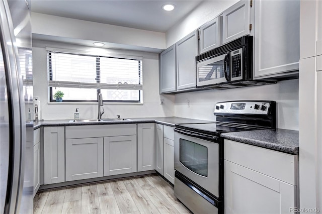 420 Wright St Unit 101, Lakewood, CO 80228 - kitchen with stainless steel appliances, dark countertops, light wood-style floors, recessed lighting, and gray cabinets