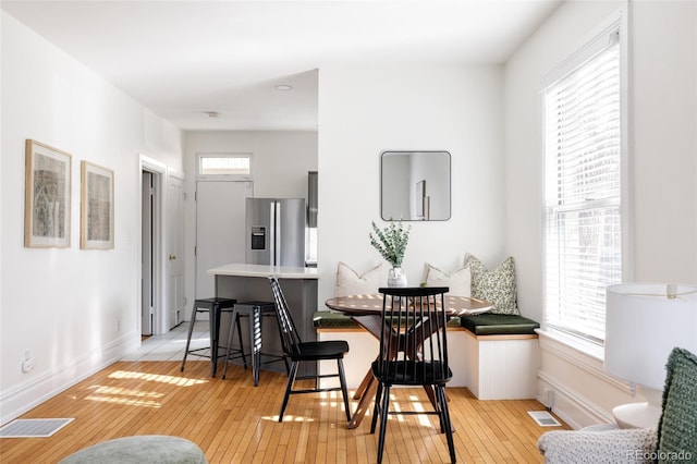 dining room with plenty of natural light, light wood-style flooring, breakfast area, and visible vents