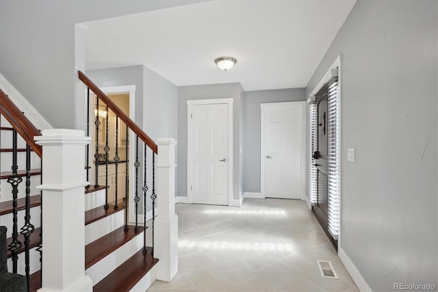 foyer entrance featuring light tile patterned floors and a wealth of natural light