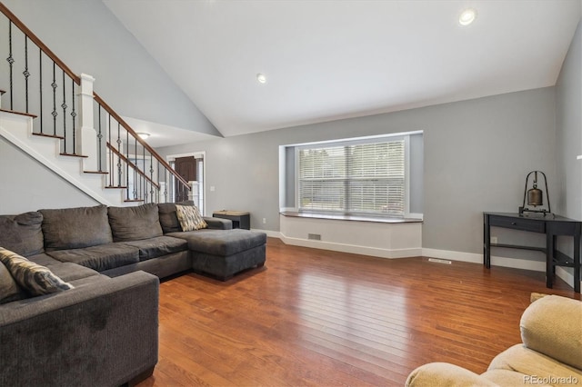 living room with hardwood / wood-style floors and high vaulted ceiling