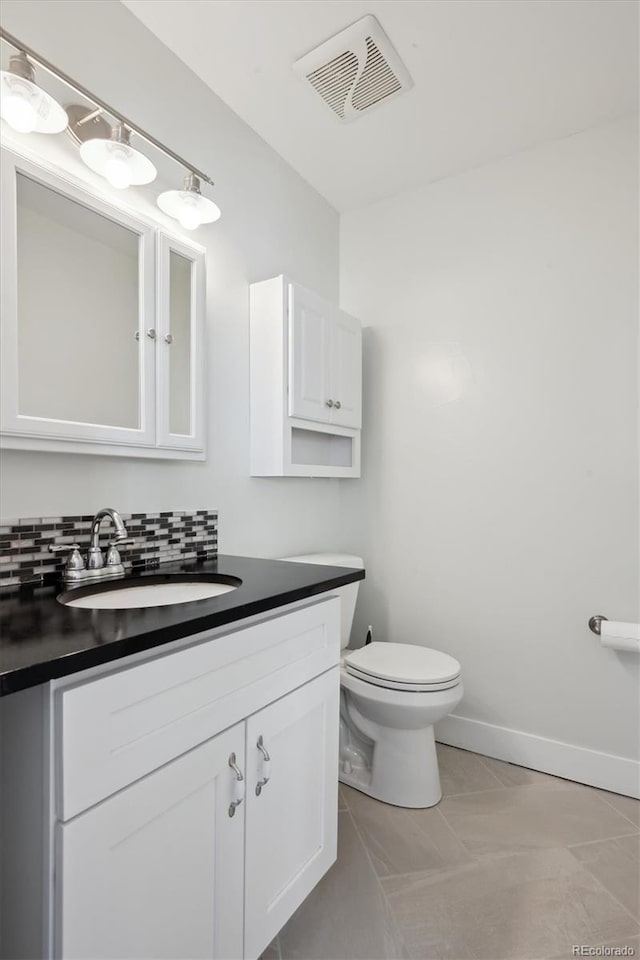 bathroom with vanity, toilet, tile patterned flooring, and decorative backsplash