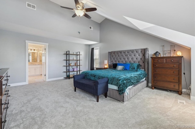 carpeted bedroom featuring ensuite bathroom, high vaulted ceiling, ceiling fan, and a skylight