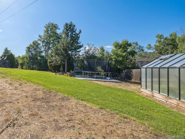 view of yard with a patio, an outbuilding, and a trampoline