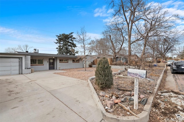 single story home featuring concrete driveway, brick siding, and an attached garage