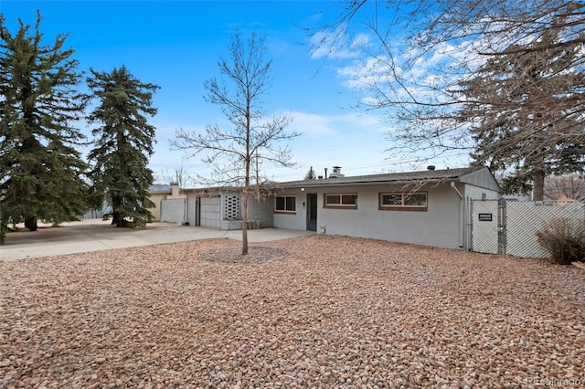 single story home with a garage, driveway, a gate, and fence