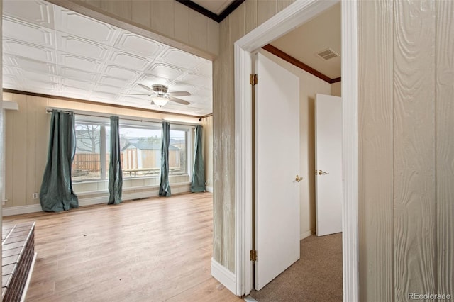 interior space with visible vents, baseboards, an ornate ceiling, light wood-style flooring, and ornamental molding