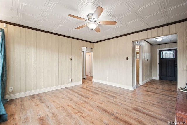 unfurnished room featuring an ornate ceiling, ornamental molding, light wood-style flooring, and baseboards