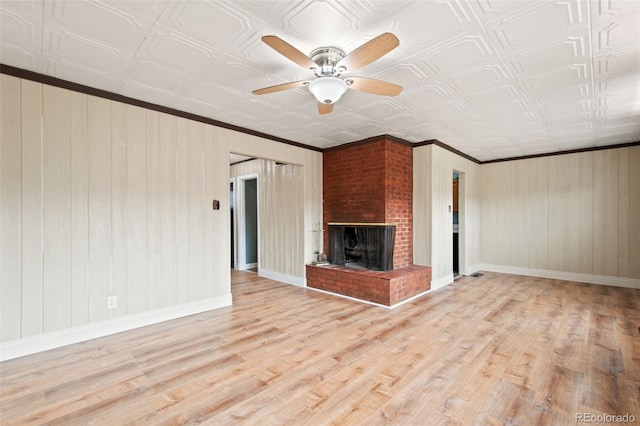 unfurnished living room featuring an ornate ceiling, a fireplace, baseboards, and wood finished floors