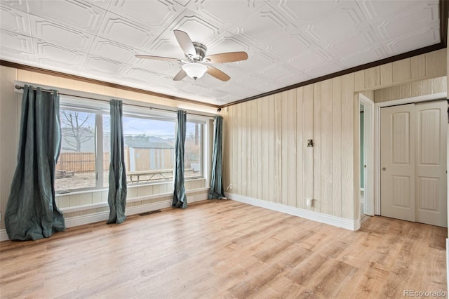 unfurnished room featuring an ornate ceiling, baseboards, and light wood finished floors