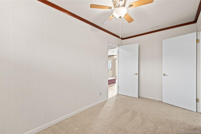 unfurnished bedroom with baseboards, visible vents, ceiling fan, crown molding, and carpet flooring