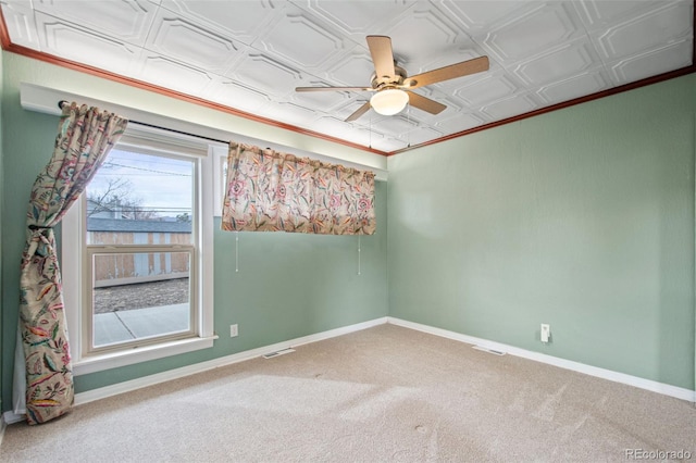 carpeted spare room with an ornate ceiling, visible vents, ceiling fan, and baseboards