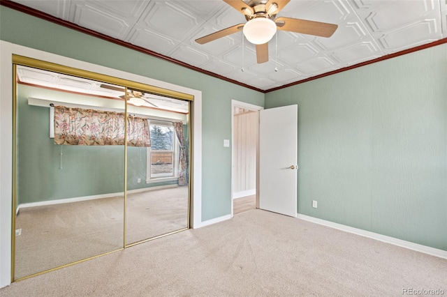 unfurnished bedroom with an ornate ceiling, ornamental molding, carpet floors, and baseboards