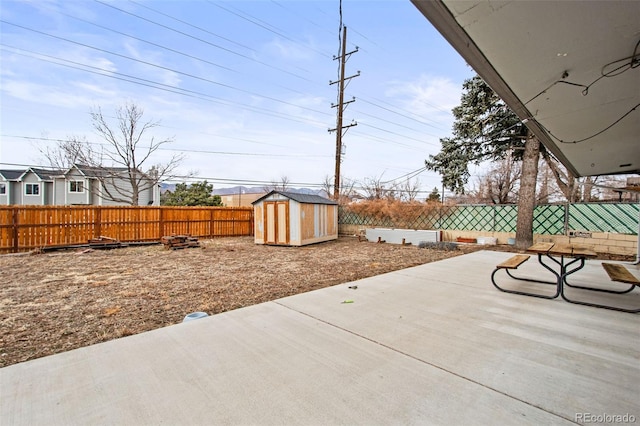 view of patio / terrace featuring an outbuilding, a fenced backyard, and a storage shed