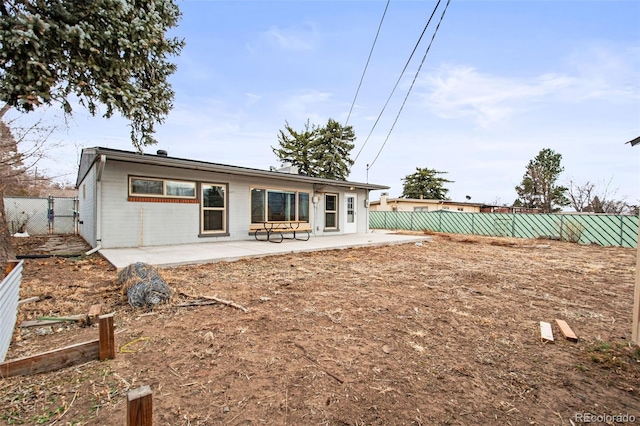 rear view of house featuring a fenced backyard and a patio