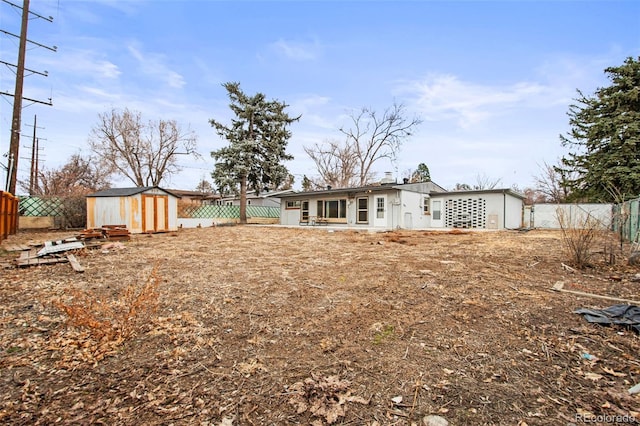 back of property featuring a fenced backyard, an outdoor structure, and a storage unit