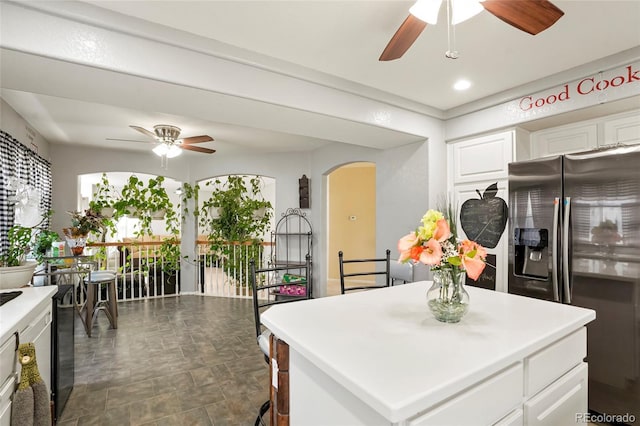 20292 E 47th Ave, Denver, CO 80249 - kitchen with stainless steel fridge, arched walkways, ceiling fan, and white cabinets
