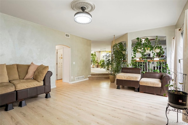 20292 E 47th Ave, Denver, CO 80249 - living room featuring visible vents, arched walkways, baseboards, and wood finished floors