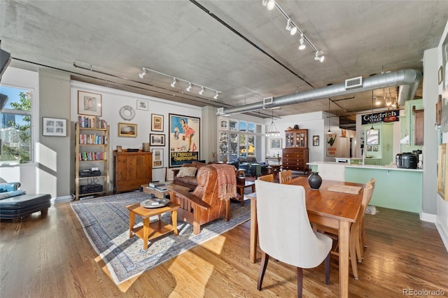 dining room featuring hardwood / wood-style floors and track lighting