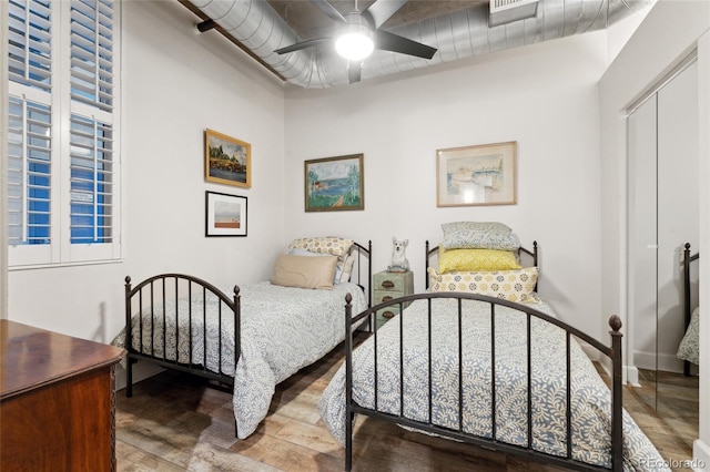 bedroom featuring hardwood / wood-style flooring, ceiling fan, and a closet