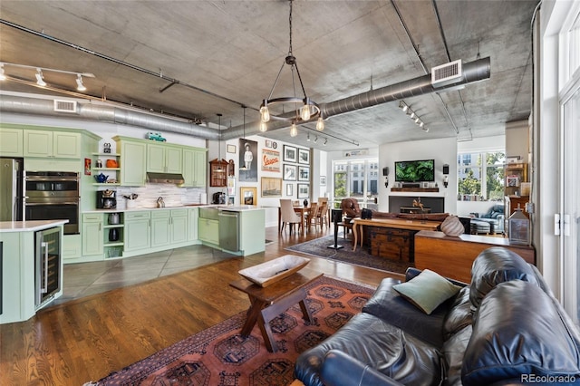 living area with visible vents, rail lighting, dark wood finished floors, and wine cooler