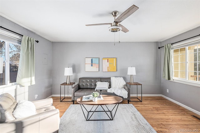 living room with light wood-type flooring and ceiling fan